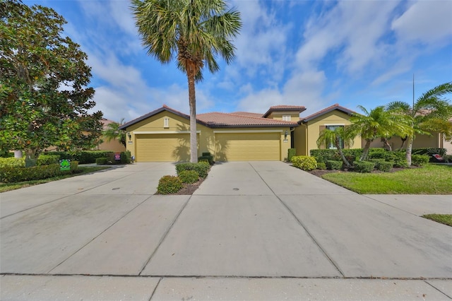 view of front of home with a garage, concrete driveway, a tiled roof, and stucco siding