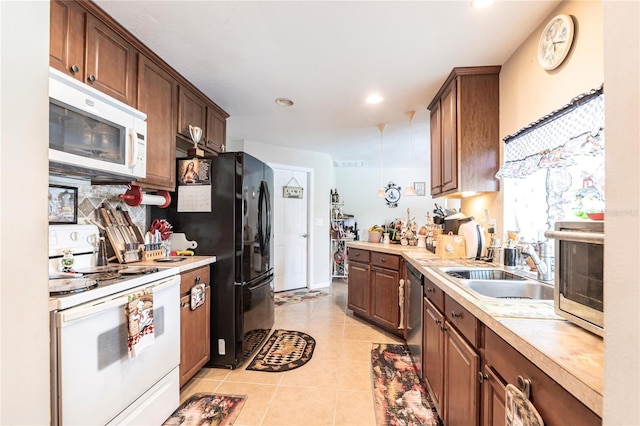 kitchen with white appliances, light tile patterned floors, light countertops, a sink, and recessed lighting