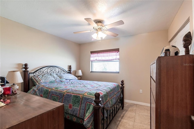 bedroom featuring light tile patterned floors, baseboards, and a ceiling fan