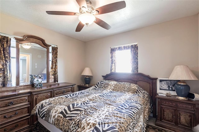 bedroom with a ceiling fan and a textured ceiling