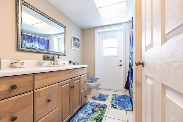 bathroom with toilet, vanity, and tile patterned floors