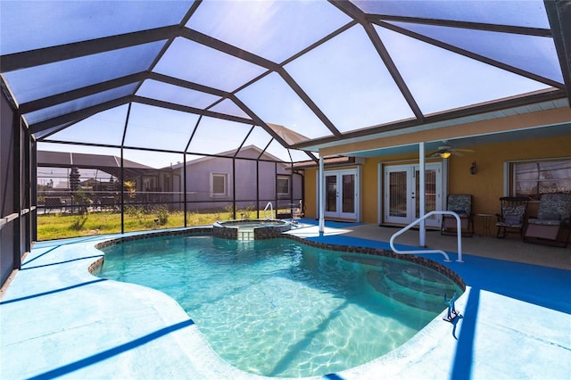 view of swimming pool with french doors, a pool with connected hot tub, glass enclosure, a patio area, and ceiling fan