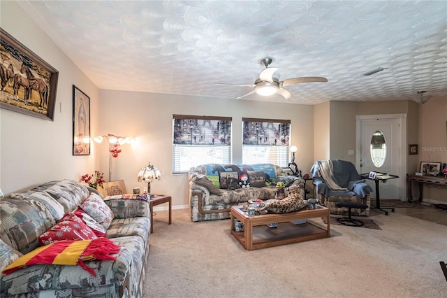 carpeted living area featuring baseboards, visible vents, and a ceiling fan