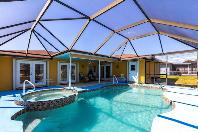 view of swimming pool featuring a lanai, a pool with connected hot tub, a ceiling fan, french doors, and a patio area