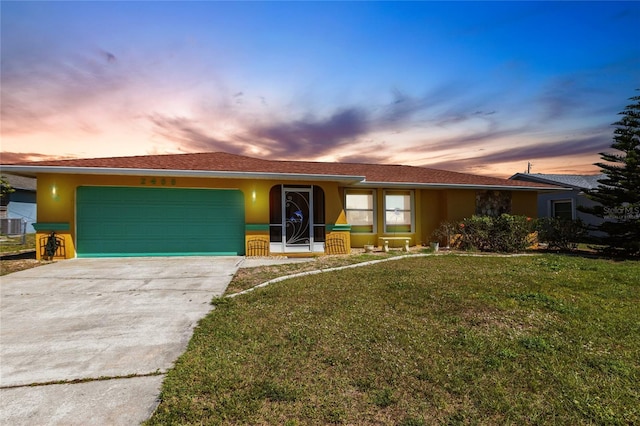 ranch-style house with a front yard, driveway, an attached garage, and stucco siding