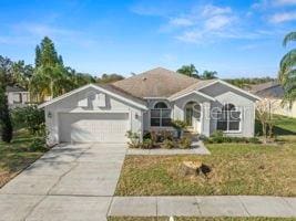 ranch-style home featuring a front lawn, driveway, and an attached garage