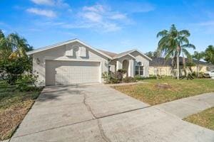 ranch-style house featuring a garage, concrete driveway, and a front yard