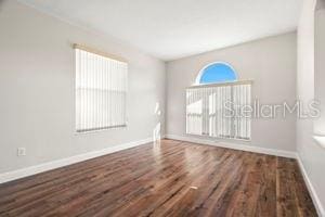 unfurnished room featuring baseboards and wood finished floors