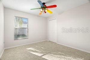 unfurnished room featuring carpet flooring, a ceiling fan, and baseboards