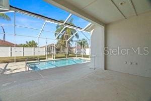 view of swimming pool featuring a fenced in pool, a patio area, and glass enclosure