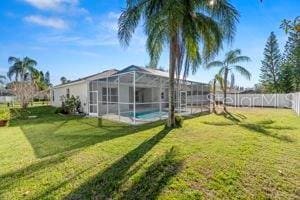 view of yard with a lanai, fence, and a fenced in pool