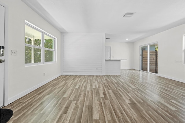 unfurnished living room featuring light wood-style flooring, visible vents, and baseboards