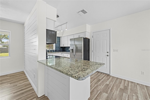 kitchen featuring light wood finished floors, visible vents, white cabinetry, stainless steel refrigerator with ice dispenser, and a sink