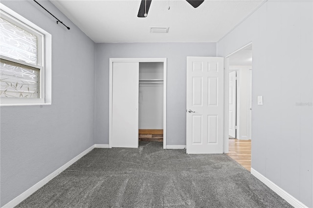 unfurnished bedroom with carpet flooring, a ceiling fan, visible vents, baseboards, and a closet