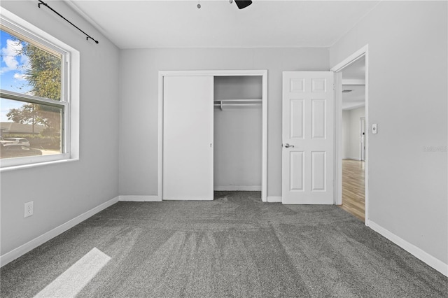 unfurnished bedroom featuring carpet floors, a closet, and baseboards