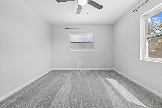 spare room featuring ceiling fan, carpet, and baseboards