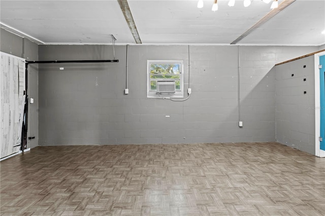 basement with concrete block wall, parquet floors, and cooling unit