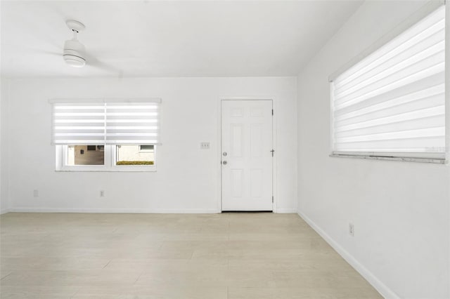 spare room featuring light wood-type flooring and baseboards