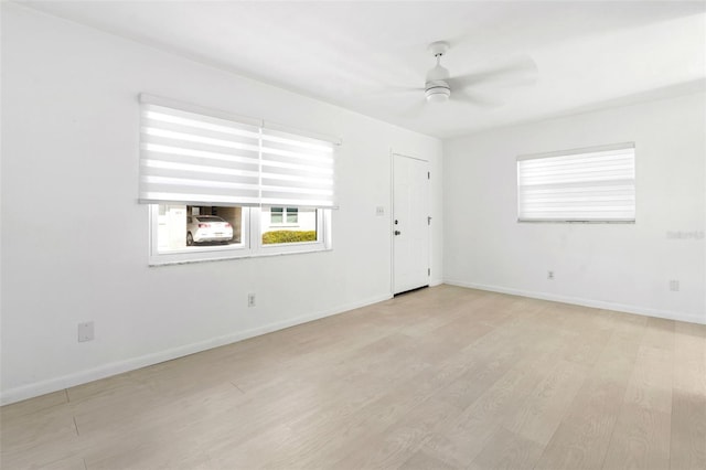 empty room with light wood-style flooring, baseboards, and a ceiling fan