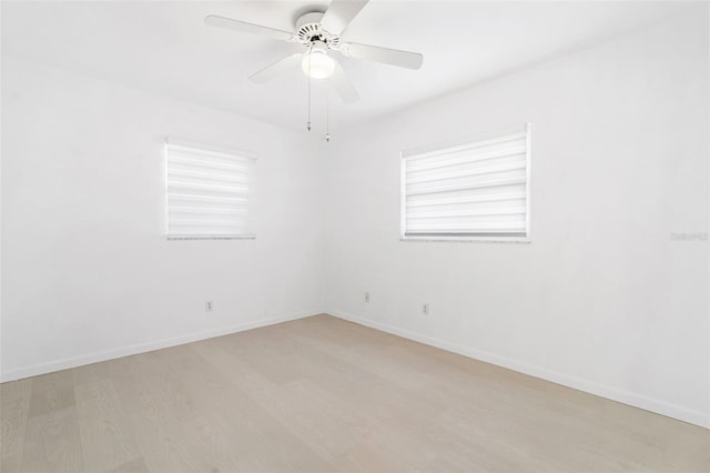 spare room with light wood-style flooring, baseboards, and ceiling fan