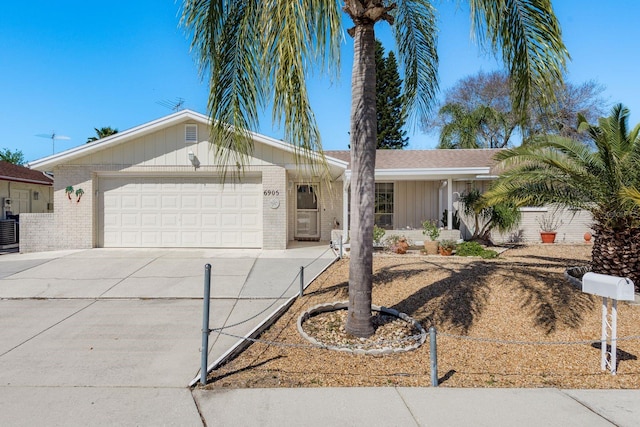 single story home with concrete driveway, brick siding, fence, and an attached garage