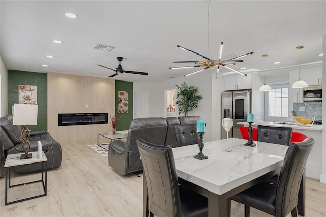 dining area featuring a large fireplace, visible vents, ceiling fan, light wood-type flooring, and recessed lighting