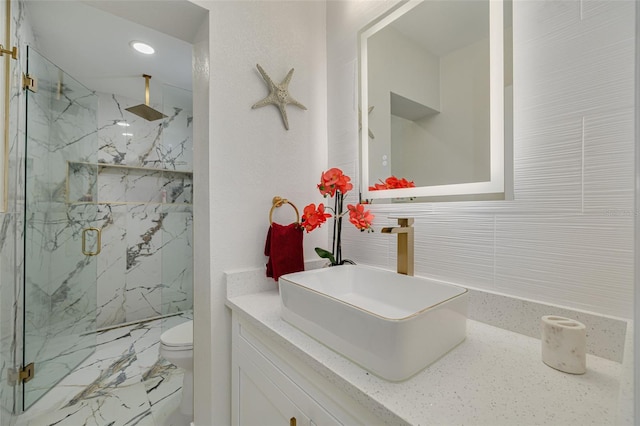 full bathroom with marble finish floor, vanity, a marble finish shower, and toilet