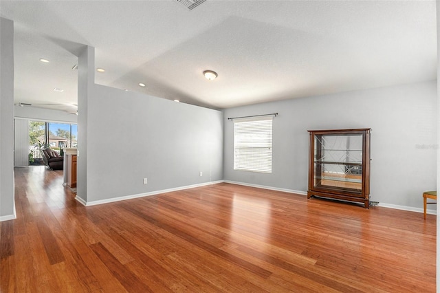 unfurnished room featuring recessed lighting, wood finished floors, visible vents, and baseboards