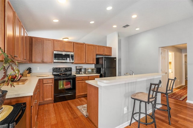 kitchen with black appliances, visible vents, light countertops, and light wood-style floors