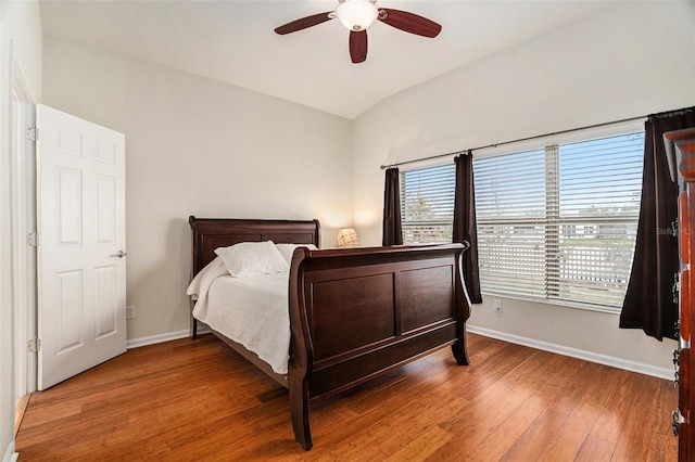 bedroom with lofted ceiling, ceiling fan, baseboards, and wood finished floors