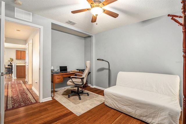 office space featuring visible vents, baseboards, and wood finished floors