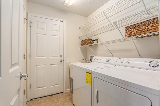 laundry room featuring laundry area, light tile patterned flooring, independent washer and dryer, and a textured ceiling