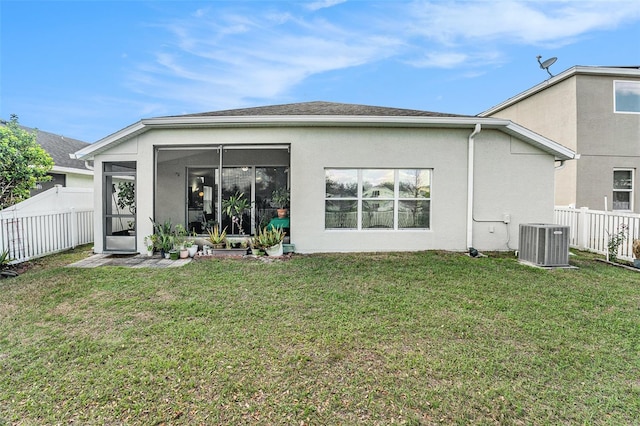 back of property featuring a sunroom, stucco siding, a lawn, and central AC unit