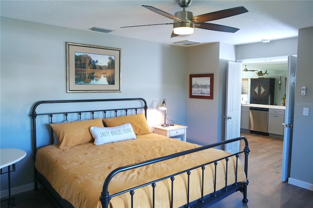 bedroom with a textured ceiling, wood finished floors, and visible vents