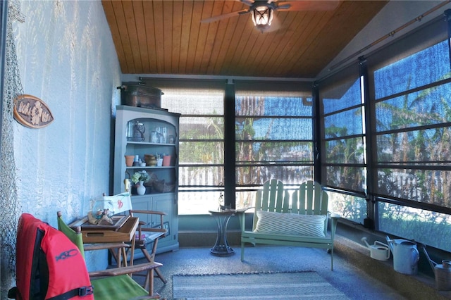 sunroom / solarium featuring lofted ceiling, wooden ceiling, and ceiling fan