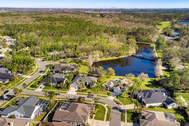 drone / aerial view with a water view, a wooded view, and a residential view