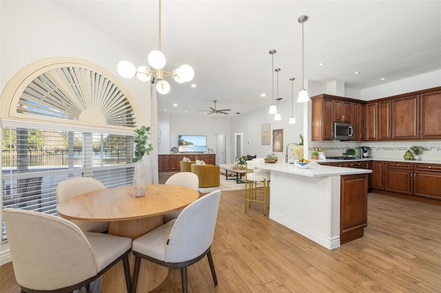 dining area featuring light wood finished floors, a ceiling fan, and recessed lighting