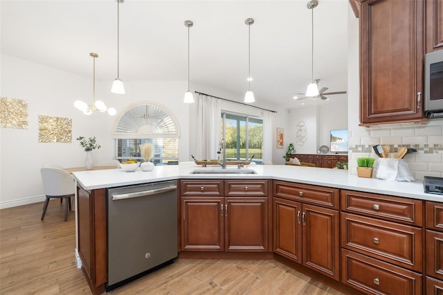 kitchen with light countertops, stainless steel dishwasher, a sink, and decorative backsplash