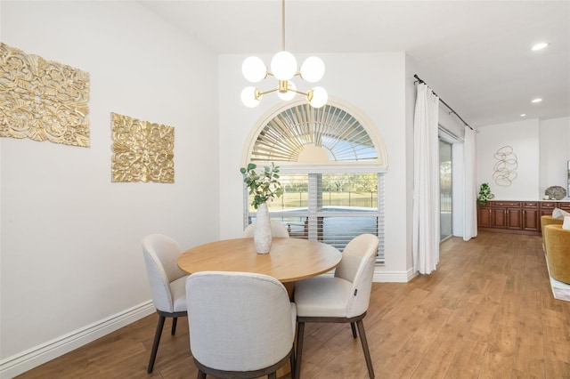 dining space with recessed lighting, light wood-style flooring, baseboards, and an inviting chandelier