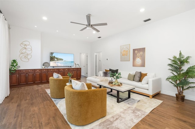 living area with baseboards, visible vents, wood finished floors, and recessed lighting