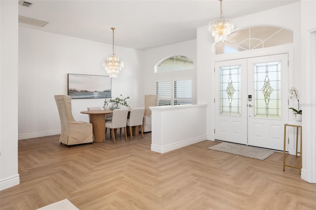 foyer entrance featuring baseboards, visible vents, a chandelier, and french doors