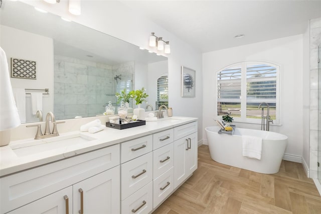 full bath featuring a freestanding bath, double vanity, a sink, and a shower stall