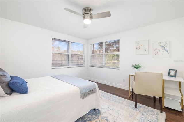 bedroom with ceiling fan, wood finished floors, and baseboards