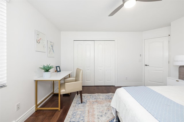 bedroom with dark wood-style floors, a closet, baseboards, and a ceiling fan