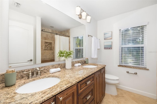 bathroom featuring toilet, baseboards, visible vents, and a sink