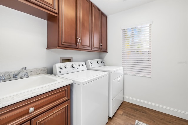 laundry room with cabinet space, a sink, wood finished floors, independent washer and dryer, and baseboards