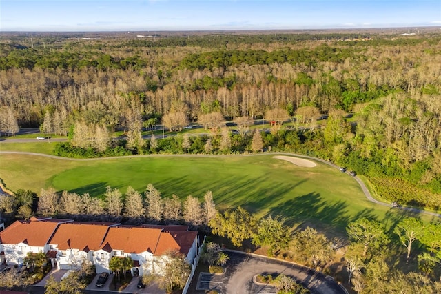 drone / aerial view with view of golf course and a view of trees