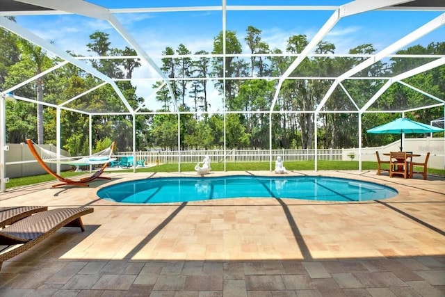 view of swimming pool with glass enclosure, a fenced backyard, a fenced in pool, and a patio