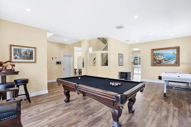 playroom with baseboards, visible vents, arched walkways, and wood finished floors