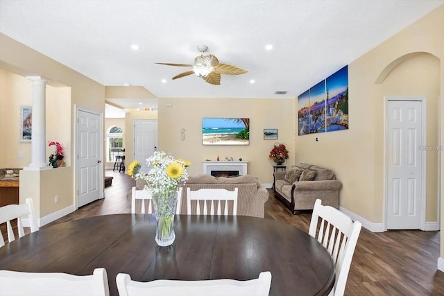 dining space featuring a fireplace, recessed lighting, ceiling fan, wood finished floors, and ornate columns